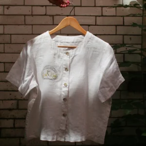 Repurposed vintage top with a hand embroidered motif. 